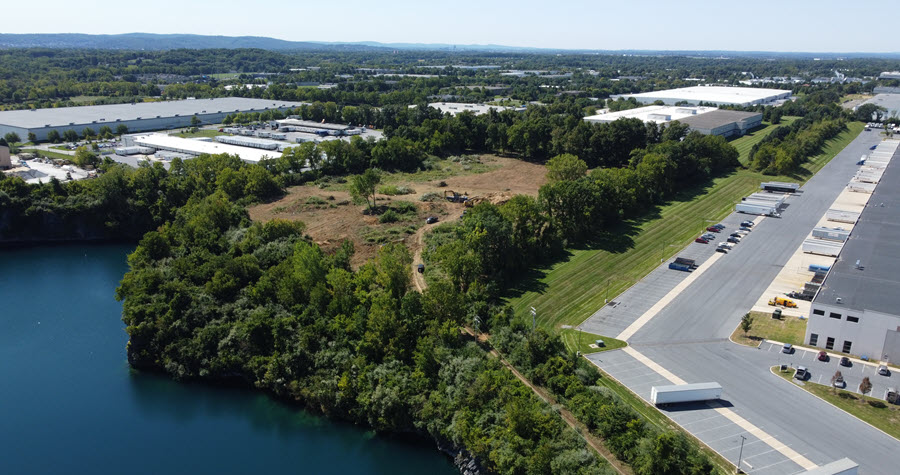 Industrial site with a lot under construction next to a quarry lake
