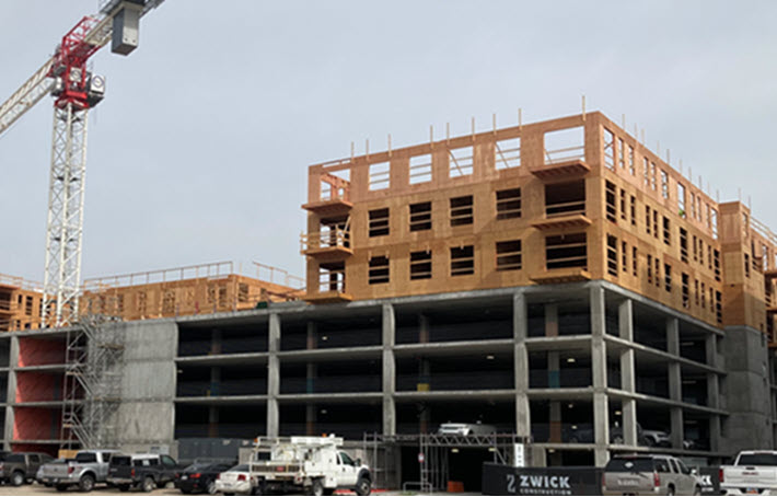Image of an unfinished residential multifamily building with a construction crane