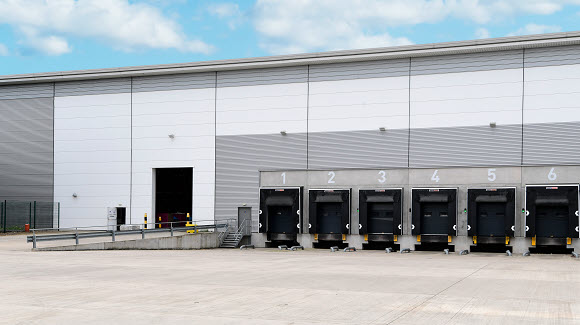 Photo of industrial building with grey numbered truck bays
