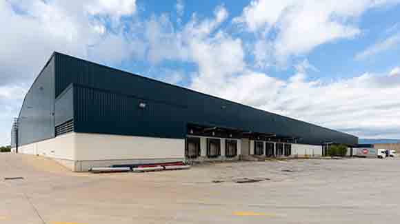 Exterior corner of a logistics warehouse with dark blue trim