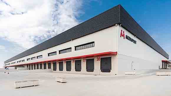 Exterior corner of a logistics warehouse with dark blue and red trim