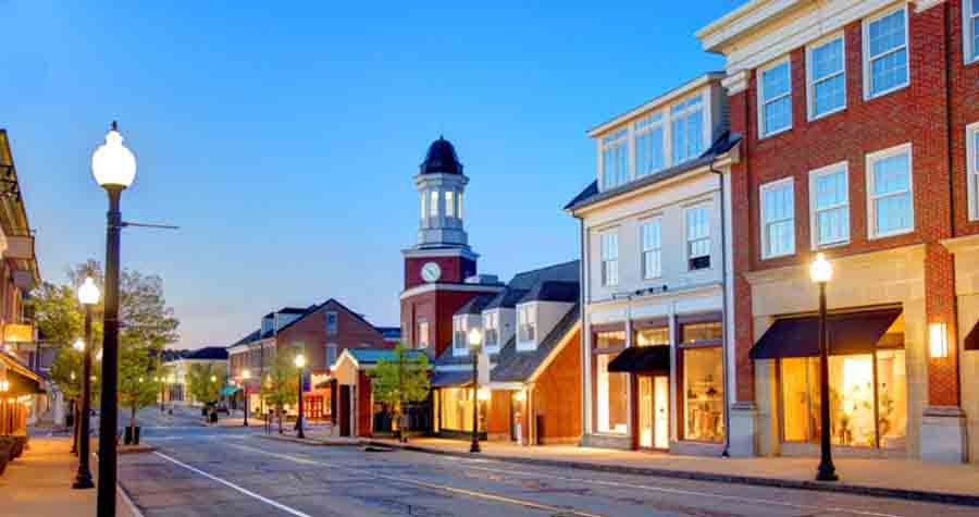 Suburban main street with retail storefronts at dusk