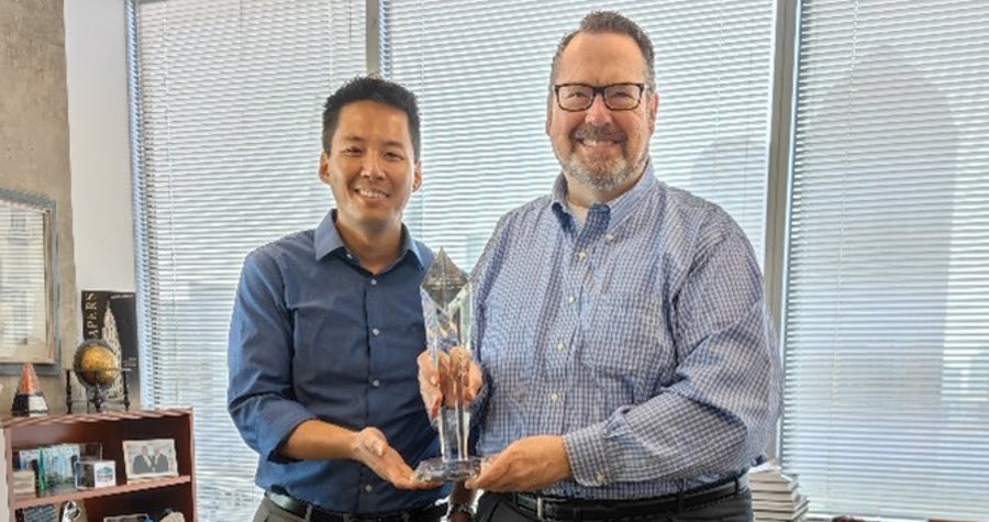 Clarion's Chuck Lathem and Stephen Lin Hold a Marriott Award Trophy