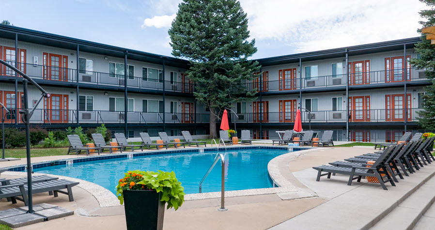 Three-story student housing building with outdoor pool and lounge chairs