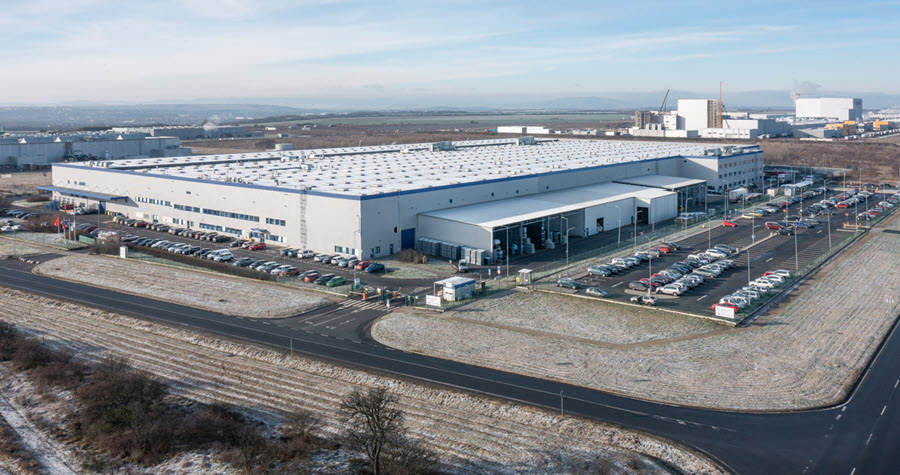 Photo of large industrial facility with large parking lots and snowy fields near other buildings