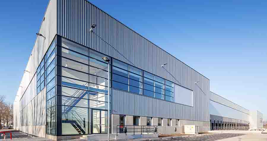 Gleaming white corner of a European distribution center with blue sky