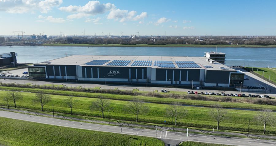 Large two-level European industrial warehouse next to a river and highway