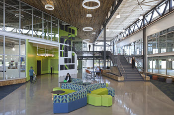 Interior of LINX with high ceilings, staircase and blue and yellow furniture