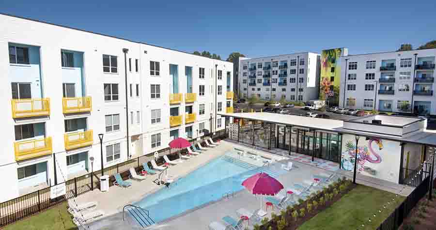Skylark Apartments: colorful swimming pool area at white 4-story apartment building