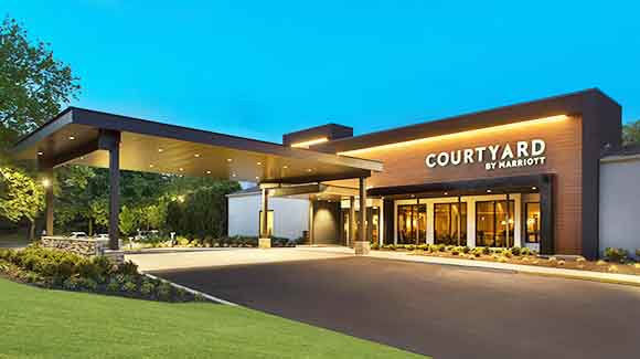 Courtyard hotel entrance with green grass and blue sky