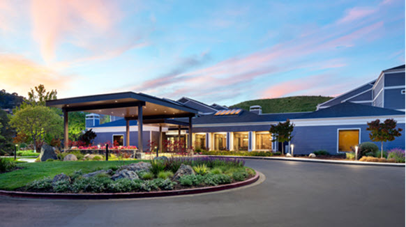 Two-story blue hotel with twilight sky