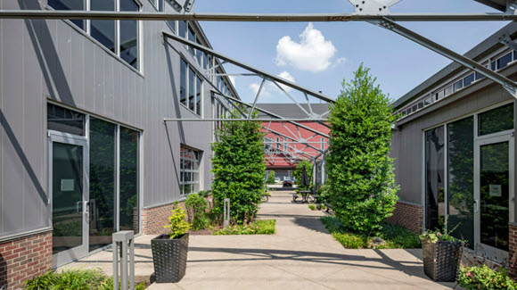 Modern open-air walkway at office and retail campus with grey overhead beams